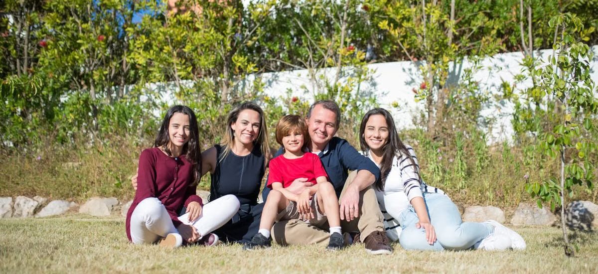 A joyful family enjoying sunny moments in a lush Portuguese garden.