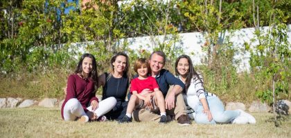 A joyful family enjoying sunny moments in a lush Portuguese garden.